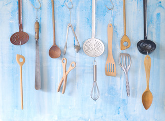 various vintage kitchen utensils, on grungy wall