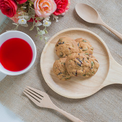 Oat cookies with pumpkin seeds and raisin on a wooden plate.