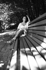 beautiful woman in a blue dress sitting on a bench