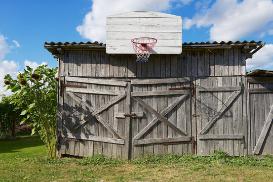 Old wooden barn with a basketball hoop attached.