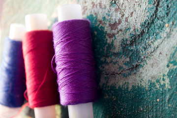 три мотка ниток на зеленном деревянном фоне