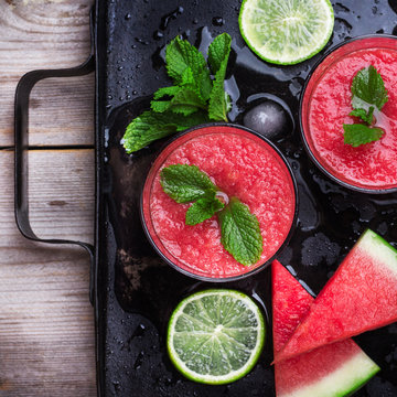 Watermelon slices and drink on a grunge table