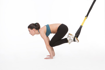 Core body excercise concept. Image of young attractive woman doing suspension training with fitness...