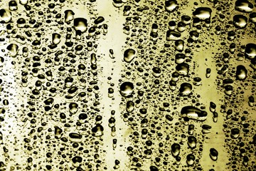 closeup drops water on gold glass background