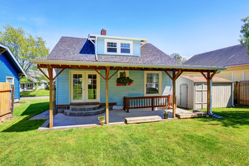 Fototapeta na wymiar Backyard of blue American house with well kept lawn around