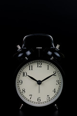 Time is up - alarm clock standing isolated on black background