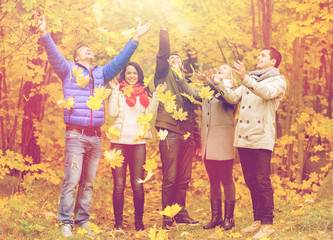 Naklejka premium group of smiling men and women in autumn park