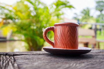 Hot black coffee on the wooden table, coffee break time beside the river.