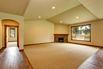 Empty living room with fireplace. Connected to kitchen area.