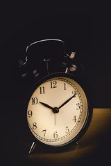 Time is up - alarm clock standing isolated on black background. with vintage filter