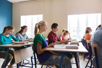 group of students with books at school lesson