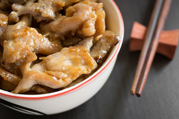 Asian marinated pork or sweet pork in white bowl, wooden chopsticks