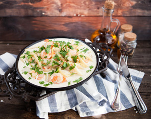 seafood - shrimp and squid  with white cream sauce on  frying pa