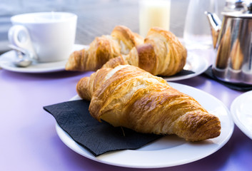 Breakfast with coffee and croissants on table