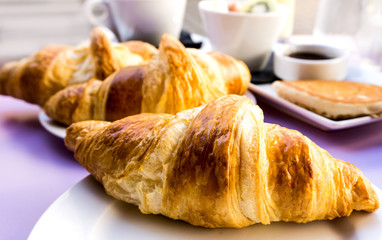 Breakfast with coffee and croissants on table