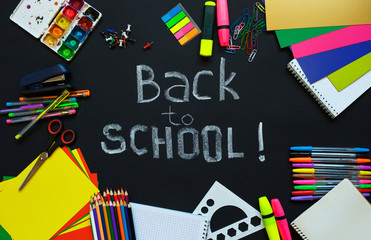 School supplies on blackboard background ready for your design