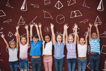 Fototapeta premium Composite image of cute pupils smiling at camera in classroom