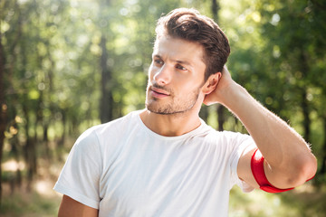 Attractive young sportsman standing in forest