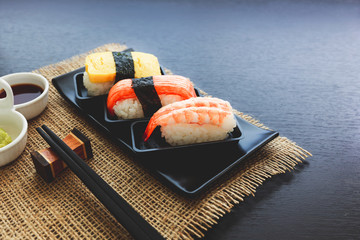 Sashimi fish, shrimp, egg set and chopstick  on the black plate