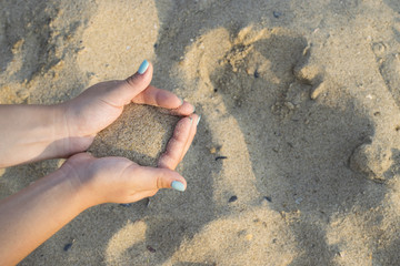 Close up on woman hands holding sand. Summer beach holiday vacation concept