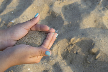 Close up on woman hands holding sand. Summer beach holiday vacation concept