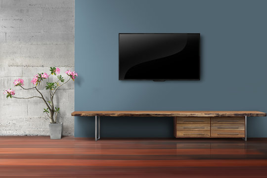 Living room led tv on blue concrete wall with empty wooden stand