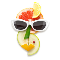 Tasty Picasso / Quirky food concept of Picasso style female face in sunglasses made of fruits and vegetables, isolated on white.