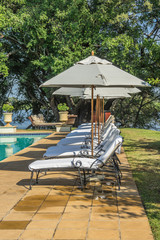 Obraz premium Deck Chairs around a beautiful swimming pool on a hot sunny day