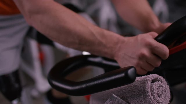  Close up of man with prosthetic leg working out on exercise bike at the gym. 