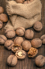 Walnut on a bag, wooden background
