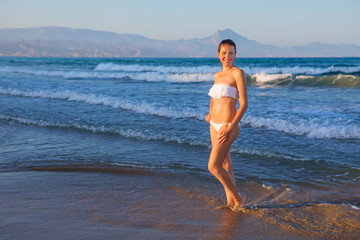 Young beautiful woman has fun at the sea in summertime