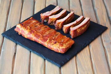 Grilled bbq smoked pork ribs on black slate board