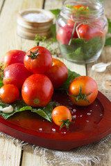 Preserving fresh and pickled tomatoes, spices and garlic on a wo