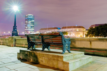 Riverside bench with buildings