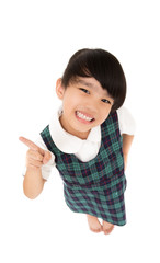 Pointing showing little girl. Humorous high angle of a grinning little girl pointing to the left of the frame with her finger. on white background