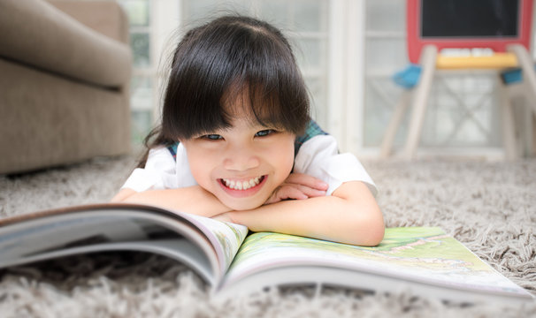 Happy Asian girl reading story book