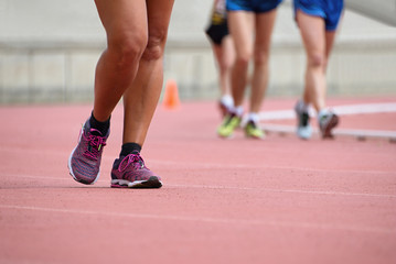 Girls on race walking on athletic track