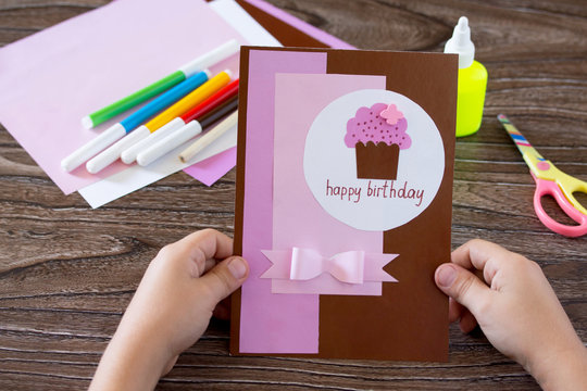 The child holds a birthday card handmade birthday inscription is