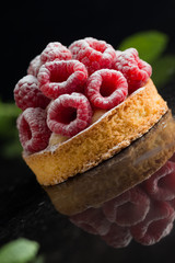 Raspberry pastry dessert on dark background. Traditional french sweet pie. Delicious, appetizing, homemade cake with custard, fresh berries and fruits. Copy space, closeup. Selective focus
