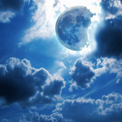 Naklejka na ściany i meble Full moon shines through the clouds in the night sky