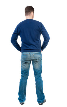 back view of Business man  looks.  Rear view people collection.  backside view of person.  Isolated over white background. bearded man in blue pullover standing with his hands in his trouser pockets.