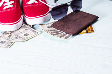 Fototapeta na wymiar The concept of vacation, passport, money, credit card, sunglasses on blue wooden background