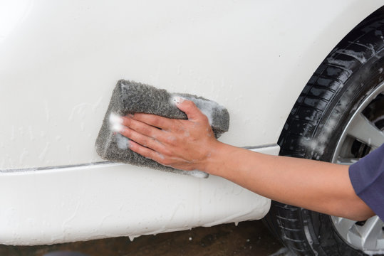 Hand man worker washing car's alloy wheels on a car wash