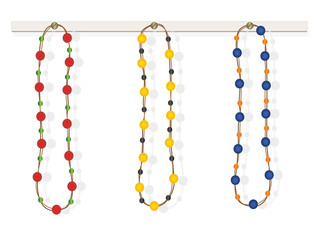 Three colorful necklaces on white wooden board.