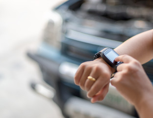 Woman touching hand smart watch, call emergency car service on city traffic accident.