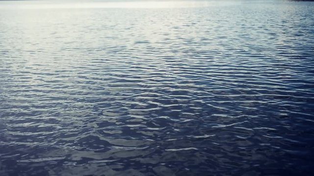 Beautiful blue rippling river water surface in sunset as natural background