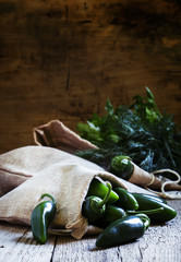 Spicy green peppers on a table in a canvas sack, selective focus