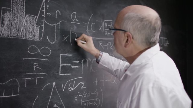  Portrait of happy smiling little scientist writing math formula on blackboard