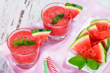Glasses of watermelon smoothie on a wooden table