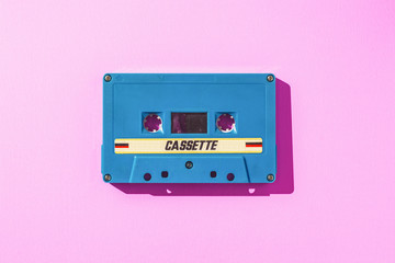 Old blue cassette tape on pink paper
